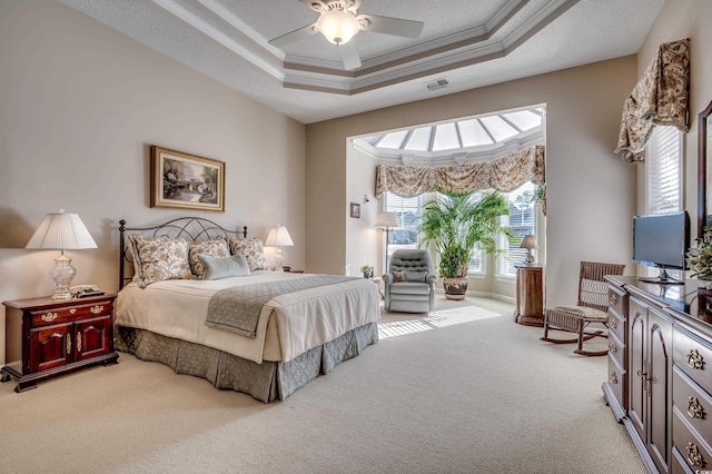 carpeted bedroom featuring ceiling fan, crown molding, and a raised ceiling