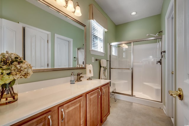 bathroom featuring a shower with shower door, tile patterned floors, and vanity