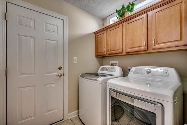 washroom featuring a textured ceiling, cabinets, and independent washer and dryer