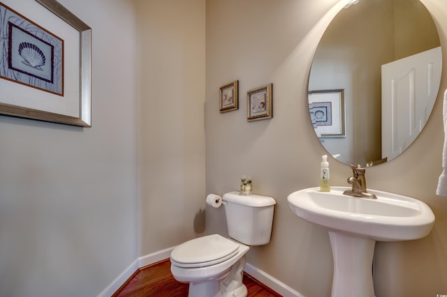 bathroom featuring toilet, hardwood / wood-style flooring, and sink