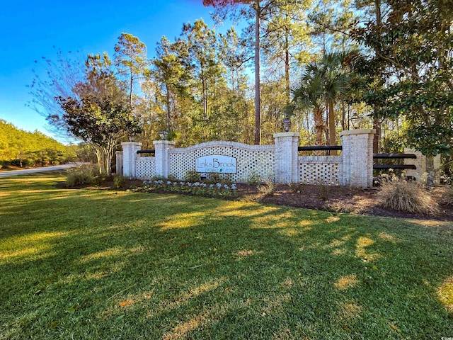 view of gate with a lawn