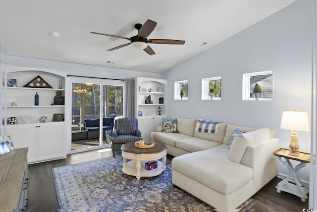 living room featuring vaulted ceiling, dark hardwood / wood-style flooring, ceiling fan with notable chandelier, and built in shelves