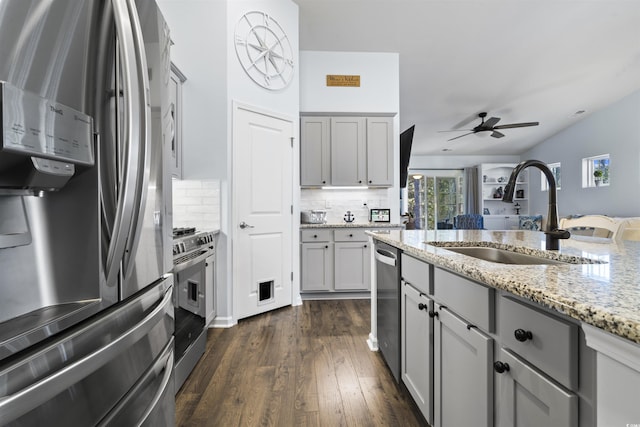 kitchen with gray cabinetry, appliances with stainless steel finishes, decorative backsplash, and sink