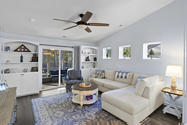 living room with vaulted ceiling, built in features, ceiling fan with notable chandelier, and dark hardwood / wood-style floors