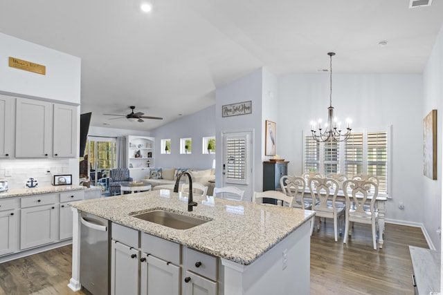 kitchen featuring ceiling fan with notable chandelier, dishwasher, an island with sink, sink, and hanging light fixtures