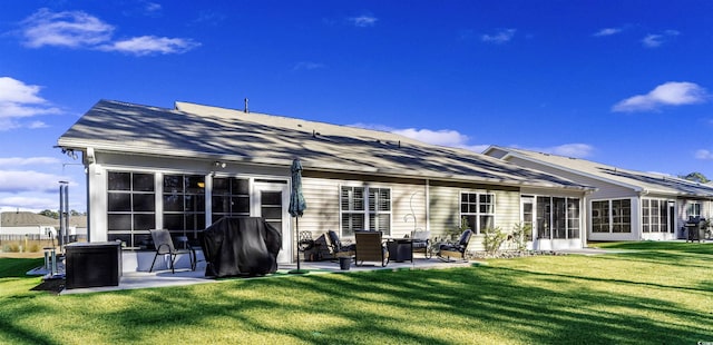 rear view of property featuring a lawn and a patio area