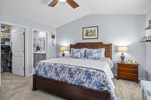 carpeted bedroom featuring ceiling fan, ensuite bath, and vaulted ceiling