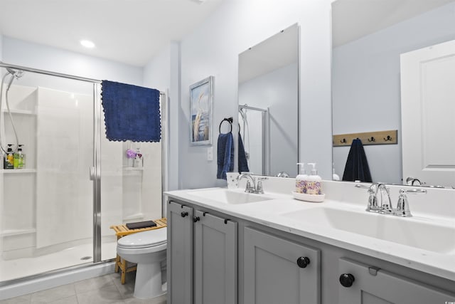 bathroom with vanity, toilet, tile patterned flooring, and a shower with door