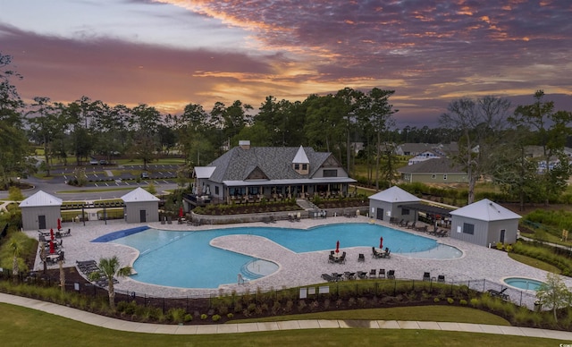 pool at dusk featuring a patio