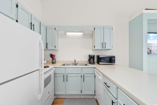 kitchen with light hardwood / wood-style floors, sink, and white appliances