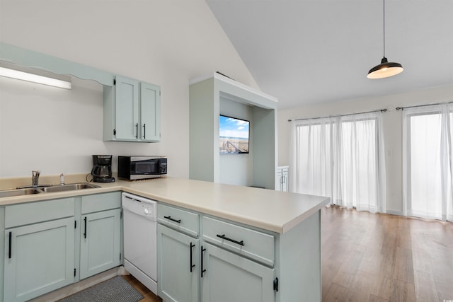 kitchen featuring lofted ceiling, dishwasher, kitchen peninsula, sink, and hanging light fixtures