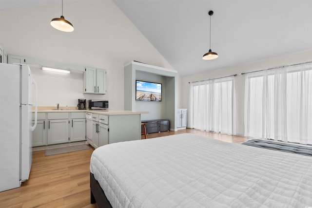 bedroom featuring high vaulted ceiling, sink, white fridge, and light hardwood / wood-style floors