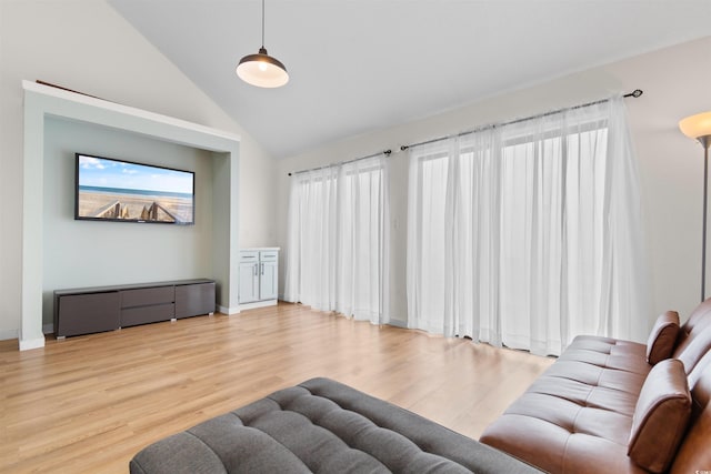 living room with high vaulted ceiling and light hardwood / wood-style floors