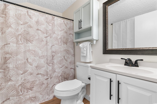 bathroom with toilet, vanity, a textured ceiling, and hardwood / wood-style floors