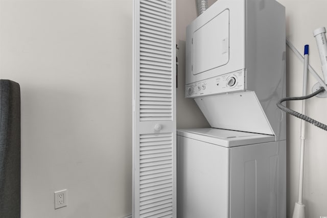 clothes washing area with stacked washer and clothes dryer