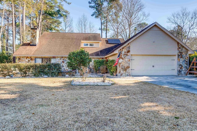 view of front of house with a garage, a front yard, and solar panels