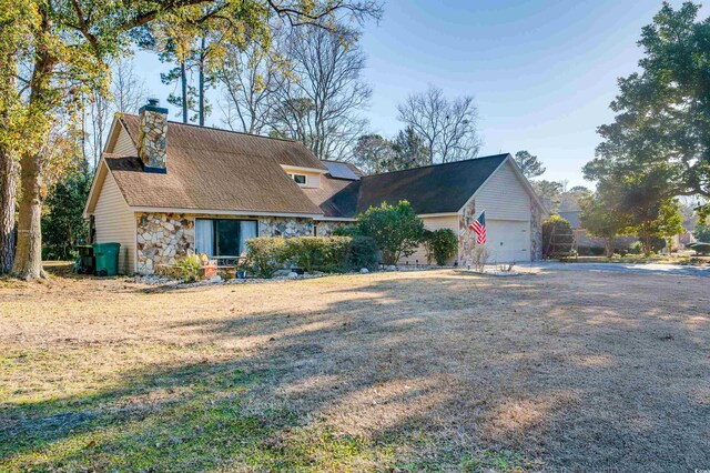 new england style home featuring a front lawn and a garage