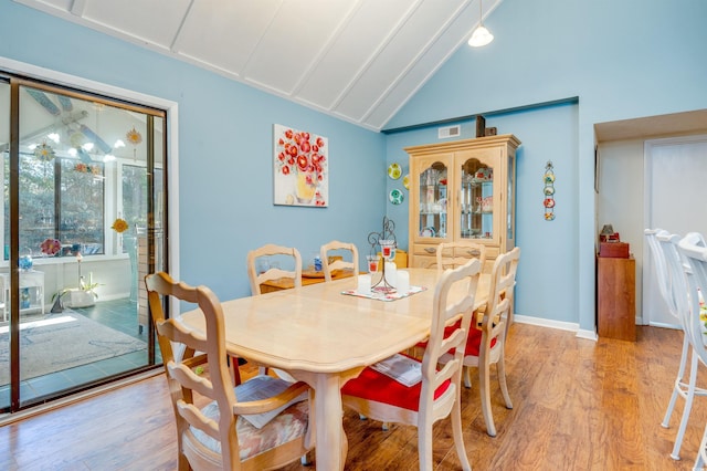 dining area featuring high vaulted ceiling and light wood-type flooring