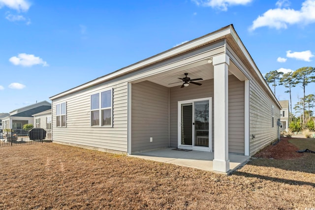 rear view of property featuring a patio area, a lawn, and ceiling fan