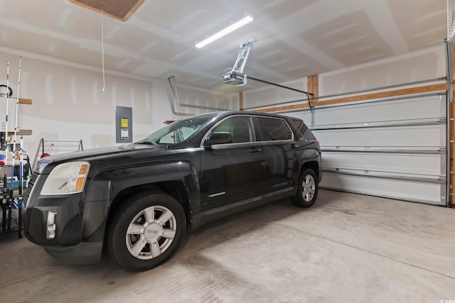 garage with a garage door opener and electric panel