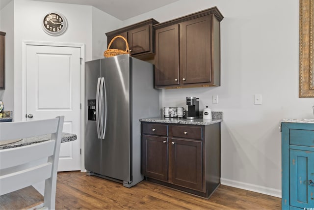 kitchen with dark brown cabinets, stainless steel fridge with ice dispenser, and dark hardwood / wood-style flooring