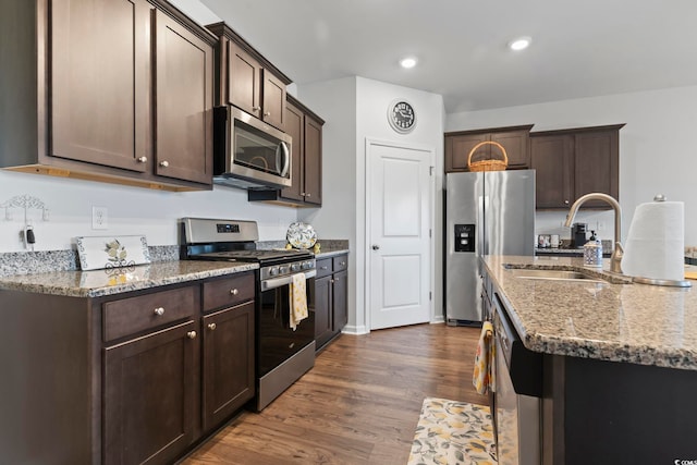 kitchen with sink, dark brown cabinetry, appliances with stainless steel finishes, and dark hardwood / wood-style floors