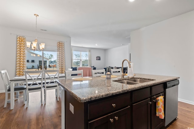 kitchen with dishwasher, sink, hanging light fixtures, an island with sink, and a chandelier