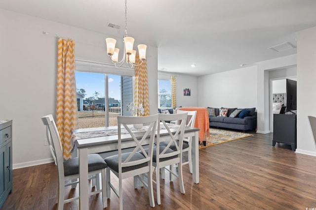 dining space with a notable chandelier and dark hardwood / wood-style flooring