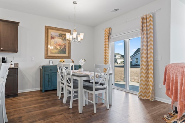 dining room featuring dark hardwood / wood-style flooring and an inviting chandelier