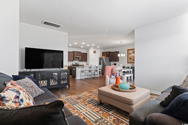 living room with dark wood-type flooring and a chandelier