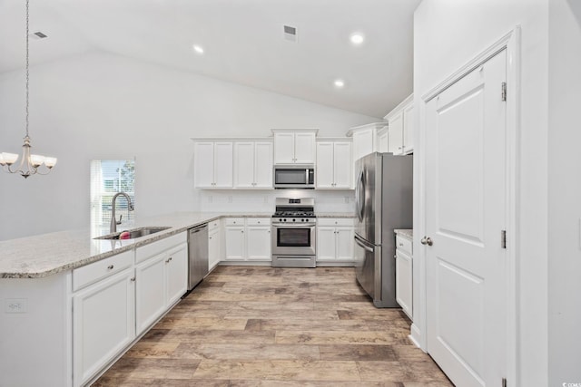 kitchen featuring stainless steel appliances, tasteful backsplash, hanging light fixtures, white cabinets, and sink