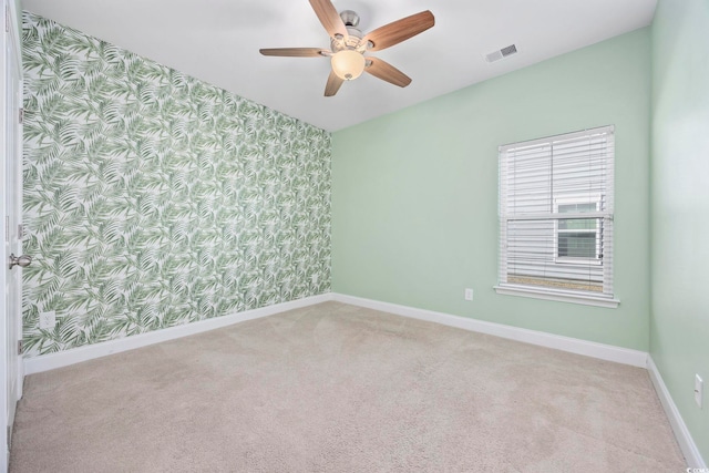 empty room featuring ceiling fan and light colored carpet