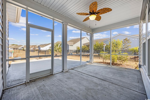 unfurnished sunroom with ceiling fan