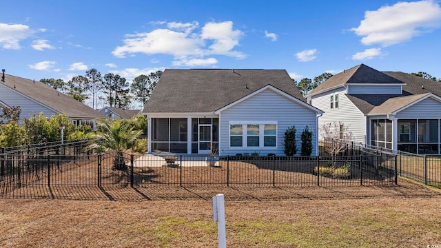 rear view of house with a sunroom and a lawn