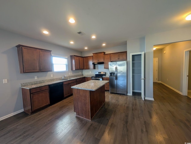 kitchen with light stone countertops, a kitchen island, stainless steel appliances, sink, and dark hardwood / wood-style floors