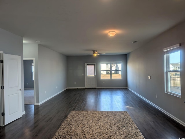 spare room with ceiling fan, a healthy amount of sunlight, and dark hardwood / wood-style flooring