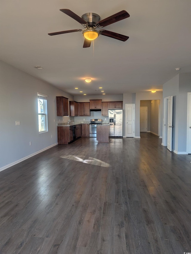 unfurnished living room featuring ceiling fan and dark hardwood / wood-style flooring