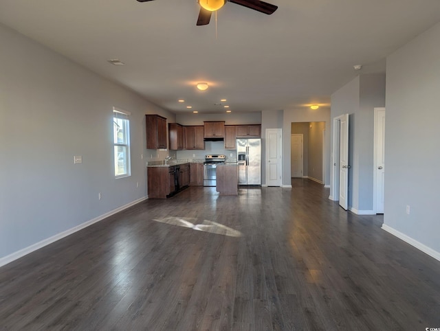 kitchen with ceiling fan, appliances with stainless steel finishes, dark wood-type flooring, a kitchen island, and sink