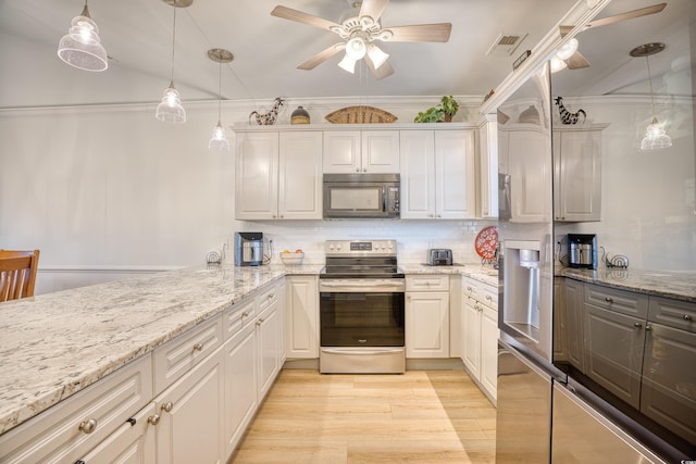 kitchen featuring stainless steel electric stove, light stone countertops, and hanging light fixtures