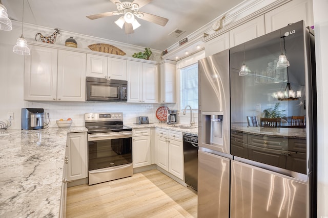 kitchen featuring black appliances, decorative backsplash, sink, hanging light fixtures, and white cabinets