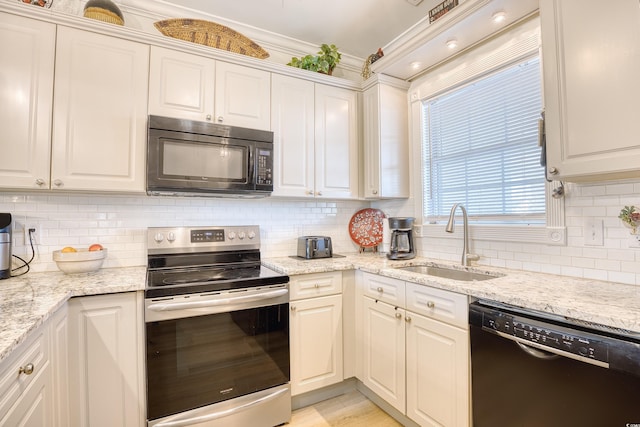 kitchen with black appliances, decorative backsplash, sink, white cabinetry, and light stone counters