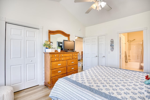 bedroom featuring ceiling fan, ensuite bathroom, lofted ceiling, and light wood-type flooring