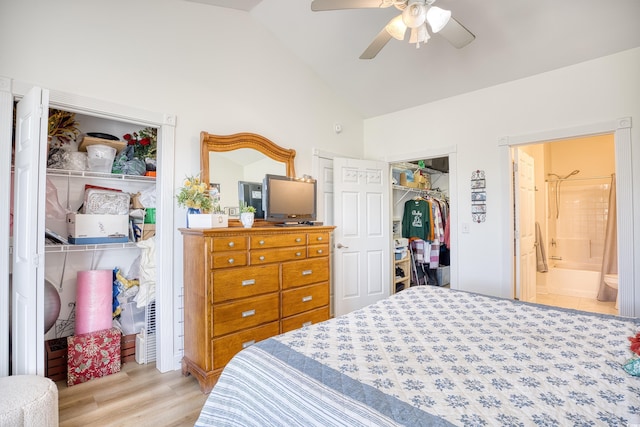 bedroom featuring ceiling fan, ensuite bath, vaulted ceiling, and light hardwood / wood-style floors