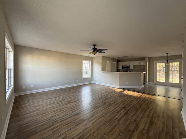 unfurnished living room with french doors, ceiling fan, a textured ceiling, and dark hardwood / wood-style floors