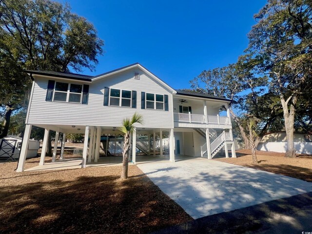 view of front facade with ceiling fan, a storage shed, covered porch, and a carport