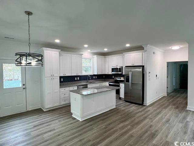 kitchen with white cabinetry, crown molding, appliances with stainless steel finishes, and a sink