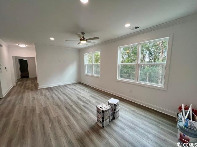 unfurnished living room with crown molding, baseboards, and wood finished floors