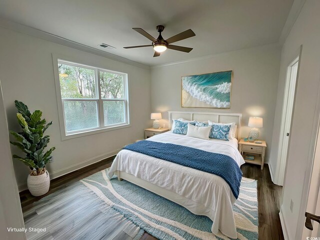 bedroom with dark wood-type flooring, ceiling fan, and crown molding