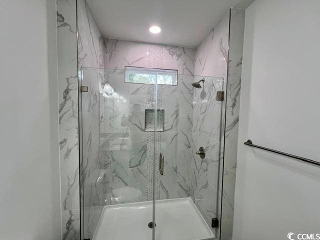 bathroom with a shower with door