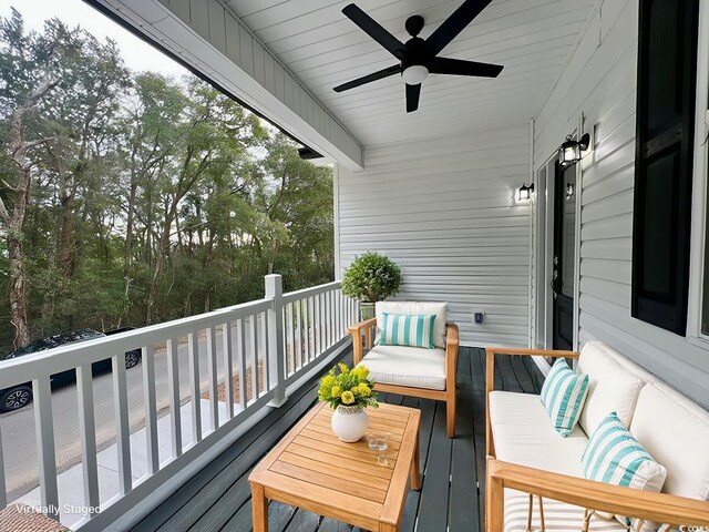 wooden terrace with ceiling fan and an outdoor hangout area